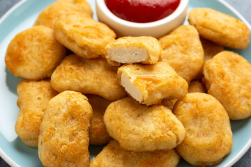 Vegetarian vegan crispy nuggets with ketchup on blue plate