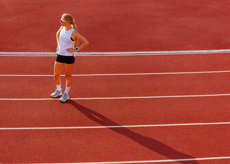 young woman in sports uniform stands at the stadium. sport exercise. healthy lifestyle