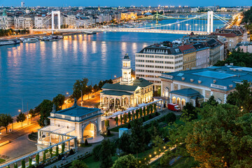 Fototapeta premium Hungary Budapest eving cityscape about the Danube river with Erzsebet and Szabadsag bridges on the background. Ybl palace and Varkert bazaar on the front