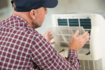 senior man assembling an air conditioning unit