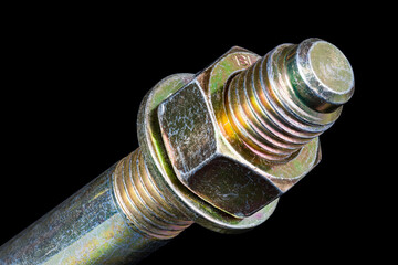 Hexagonal nut and washer on metal galvanized anchor bolt end on black background. Artistic detail of thread on anchoring rod into concrete with yellow chromate conversion coating to protect corrosion. - obrazy, fototapety, plakaty