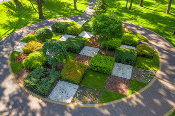 Topiary flower bed in the park, divided into square sections, aerial view.