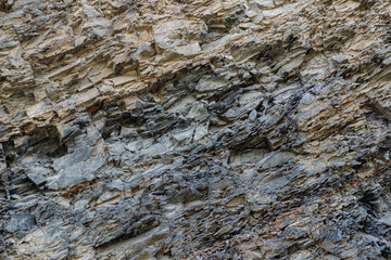 Complete setting of the textures of the face of a smooth rock with stratum outdoors.