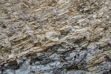 Complete setting of the textures of the face of a smooth rock with stratum outdoors.