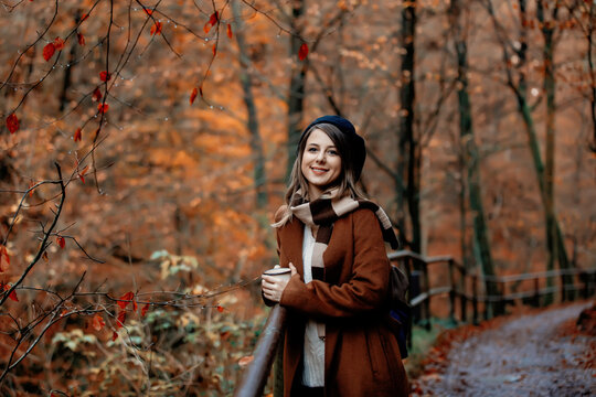 Young woman with cup of coffee in an autumn season park