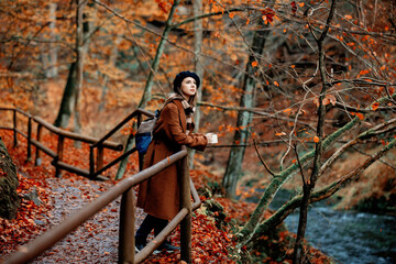 Young woman with cup of coffee in an autumn season park