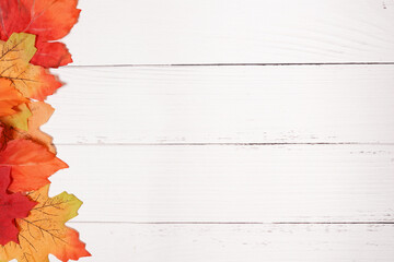 white vintage rustic wooden background with autumn yellow and red leaves, copy space