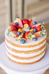 Cake for a holiday decorated with fresh strawberries, blueberries