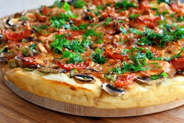 pizza of champignons, tomato, ham, sausages, sprinkled with parsley and homemade dill close-up