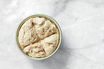 Tahini round halva plain traditional Turkish sweetness marble table background. Sweet vegetarian comfort food consept