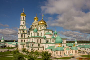 Fototapeta na wymiar the white-stone Cathedral of the Resurrection of Christ in the New Jerusalem Monastery on a sunny summer day against a blue cloudy sky in Istra Moscow Region