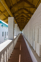 Fototapeta premium Istra, Moscow Region, Russia - August, 22, 2021: a long gallery on the white stone fortress wall of the monastery in New Jerusalem