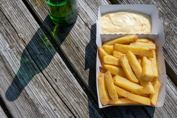 Paper box with french fried potato sticks served outdoor