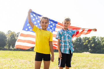 Happy children covered herself with the American flag celebrate July 4. Memorial, Independence day,...