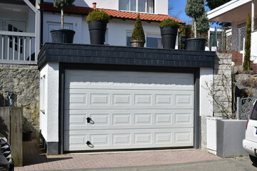 Moderne Beton-Garage mit Automatik-Tor in der Hauszufahrt