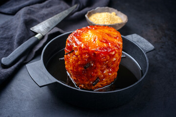 Backed caramelized pineapple with vanilla caramel sauce as top view on a modern design cast iron pan with copy space