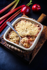 Traditional English crumble cake with rhubarb and apple with backed topping served as close-up in...