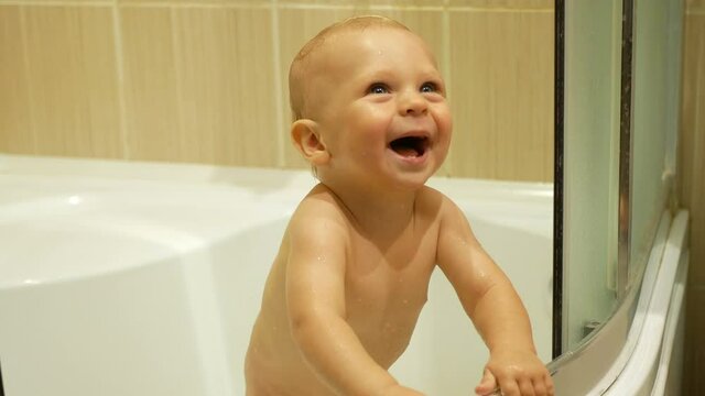 A very positive little boy is bathing in the bathroom.