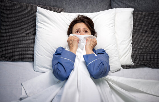 Worried Woman With Nightmares Lying In Bed And Covering Face With Blanket. Middle Aged Brunette Unable To Sleep At Night Because If Fear.