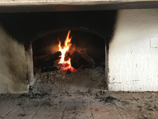 fire in the fireplace and white burnt wall. background with gray ashes and coals. place for text