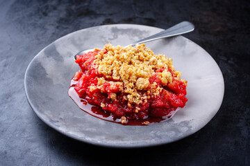 Modern style traditional American crumble cake with rhubarb and apple with backed topping served as...