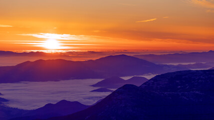 Foggy dawn in the mountains, drone view.