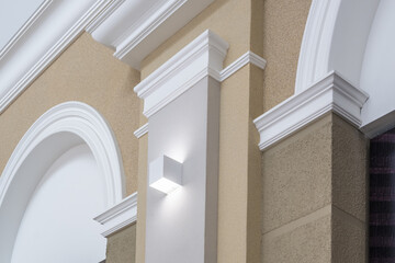 Detail of corner ceiling with intricate crown molding on column with spot light