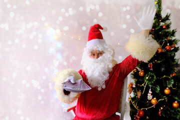 elderly santa claus with a white beard congratulates children and adults, holds banknotes in his hand, gives them, concept of christmas, holiday discounts, shopping, gifts