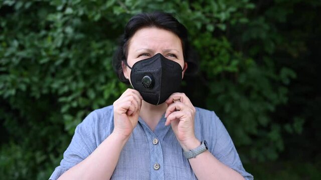 Woman in medical mask outdoors. Static camera. High quality 4k footage