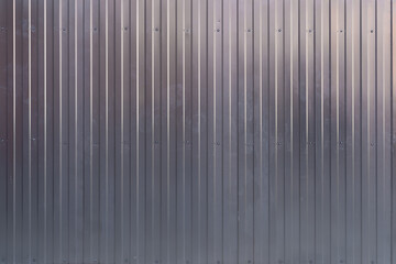 Metal fence made of galvanized iron gray profile sheet as a mirror background.