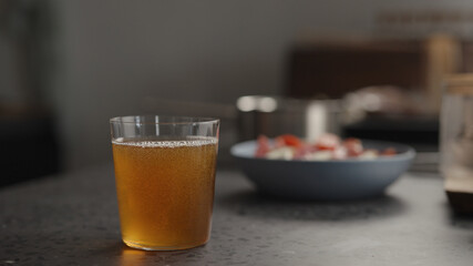 amber drink in tumbler glass on concrete countertop