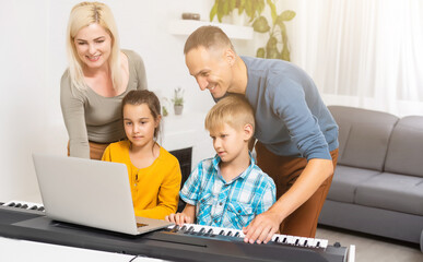 Brother and sister play the synthesizer. Children play at piano. family games