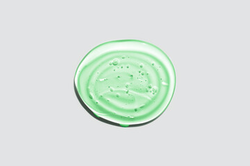 Green transparent round gel drop isolated on white background. Top view. Virus protection or cosmetics concept. Face Serum texture close up