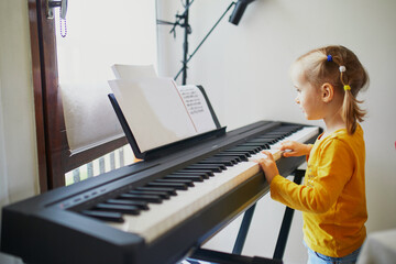 Adorable little girl playing piano