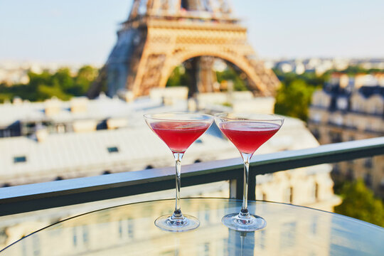 Two Cosmopolitan cocktails in traditional martini glasses with view to the Eiffel tower, Paris, France