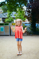 Adorable preschooler girl playing in park on a summer day