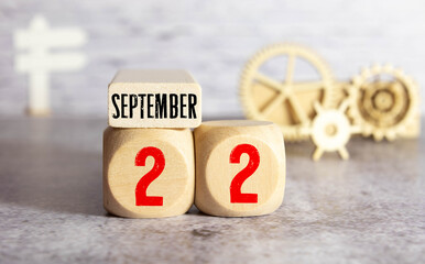 September 22st. Day 22 of month, daily calendar on white table with reflection, with light blue background.