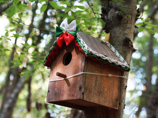 wooden decorated birdhouse on a tree in the forest