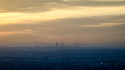 Panoramic of the area of the four towers of Madrid at sunset with the sun in the background