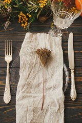 Modern plate with vintage cutlery, linen napkin, herb on wooden table with pumpkins and autumn...