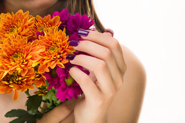 Skincare cosmetic. Unrecognizable latin woman manicure pink nails with Autumn chrysanthemum blossom 