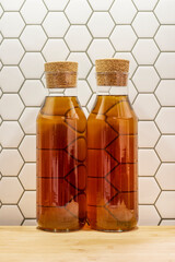Glass bottles with cork stoppers filled with lemon tea on a bamboo wood table