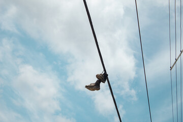Obraz premium Electricity cable. Shoes hanging.