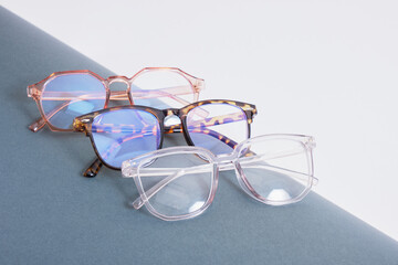 multiple pairs of eye glasses on dark gray wrapped paper, trendy fashion glasses on gray background