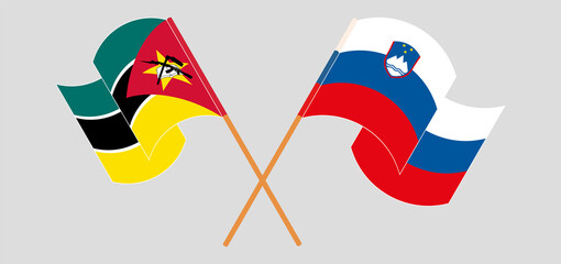 Crossed and waving flags of Mozambique and Slovenia