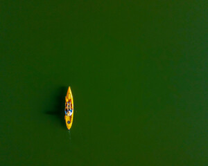 An aerial photo, taken with a drone, looking down on a lone kayaker in the green waters of the Tellico Reservoir in Tennessee.