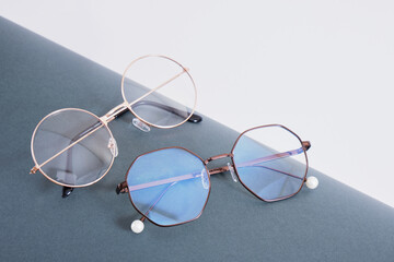 multiple pairs of eye glasses on dark gray wrapped paper, trendy fashion glasses on gray background