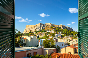 View through an open window with shutters of the ancient Parthenon on Acropolis Hill at morning in...