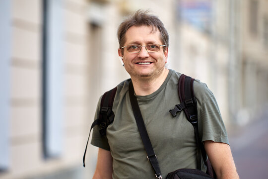 Happy Middle Aged Man With Headset And Backpack Outdoors.