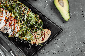 Green salad with smoked eel fish, oranges and avocado slices. Flat lay. Japanese cuisine